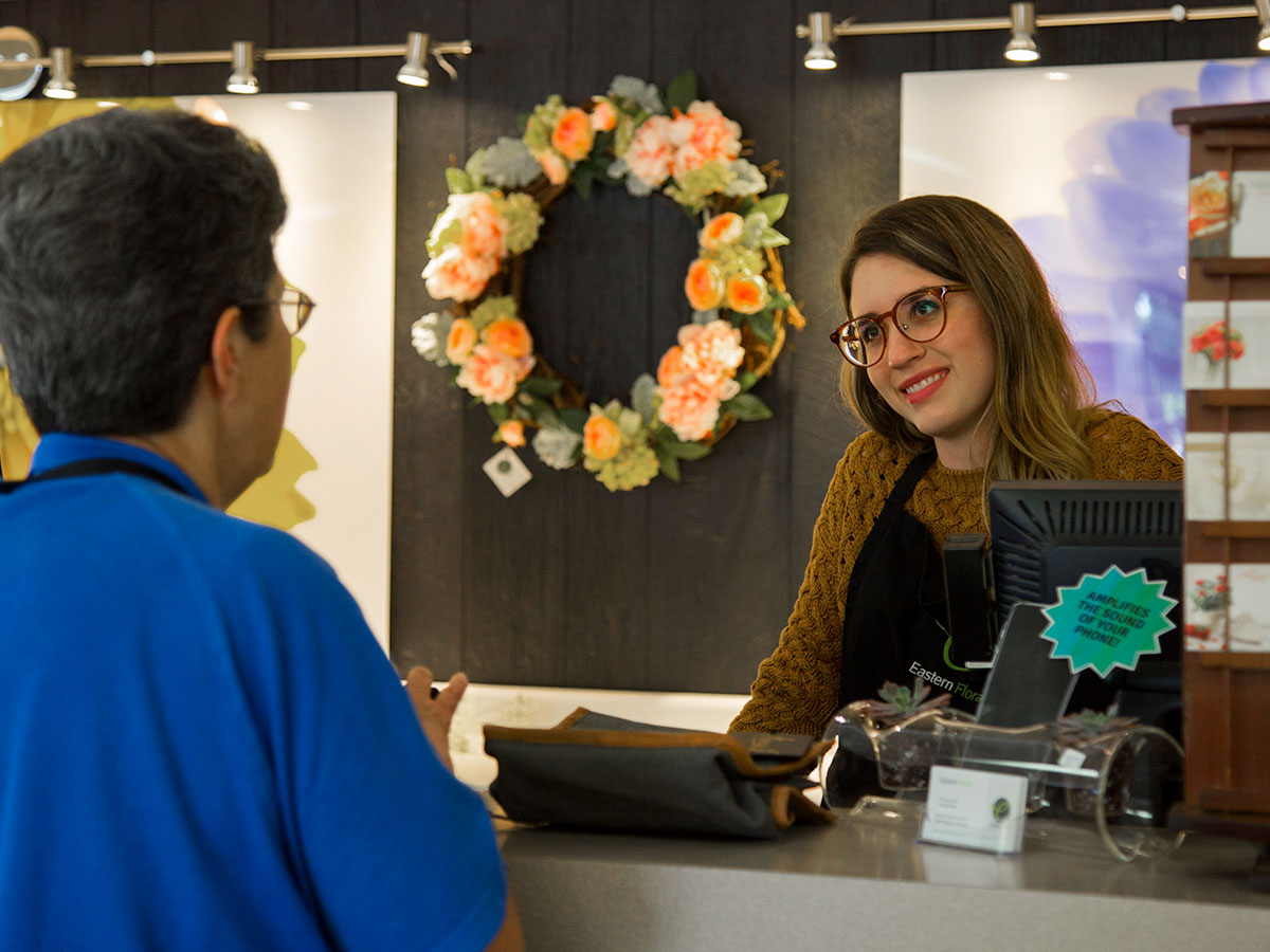 A member of the Eastern Floral staff, waiting to help at the customer service desk